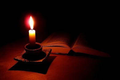 paląca się świeca i ksiązka